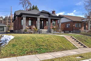 View of front of home with covered porch, central air condition unit, and a front lawn