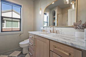 Bathroom with toilet, a wealth of natural light, and vanity