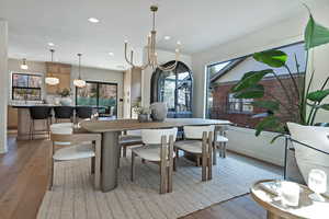 Dining area with light wood-type flooring and an inviting chandelier