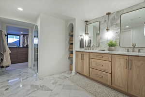 Bathroom with a shower with shower door, decorative backsplash, and vanity