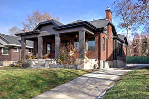 View of front of home with covered porch and a front lawn