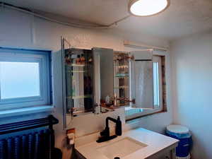 Bathroom with a textured ceiling and vanity