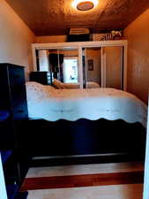 Unfurnished bedroom featuring vaulted ceiling, wooden ceiling, and hardwood / wood-style flooring