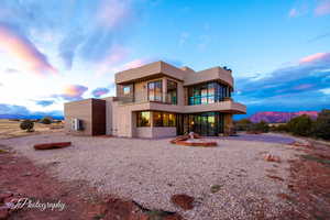 Back house at dusk featuring a balcony and a mountain view