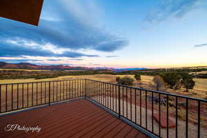 Deck at dusk featuring a rural view and a mountain view