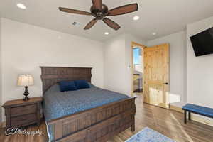 Bedroom featuring ceiling fan, connected bathroom, and hardwood / wood-style floors