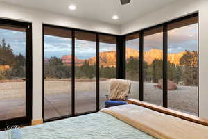 Unfurnished bedroom featuring multiple windows, access to outside, and a mountain view