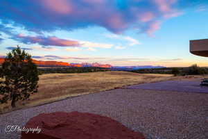 Yard at dusk with a mountain view and a patio area