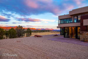 Yard at dusk featuring a balcony, a mountain view, and a patio area