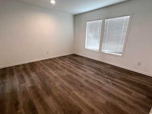 Spare room with dark wood-type flooring