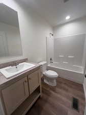 Full bathroom featuring toilet, bathtub / shower combination, wood-type flooring, and vanity