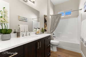 Full bathroom with vanity, wood-type flooring, toilet, and shower / bath combo