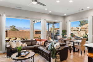 Living room featuring a mountain view, light hardwood / wood-style flooring, and ceiling fan