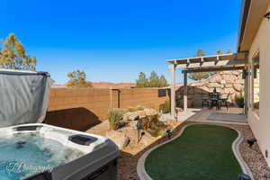 View of yard featuring a hot tub, a pergola, and a patio area