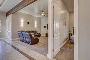 Living room with light carpet, beamed ceiling, and ceiling fan