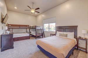 Bedroom with ceiling fan and light carpet