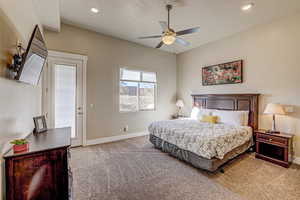 Carpeted bedroom with ceiling fan and access to outside