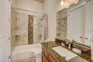 Full bathroom with vanity, toilet, and shower / bath combo with shower curtain