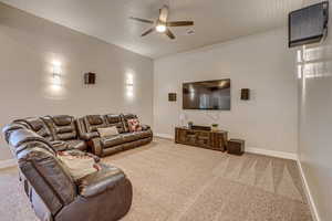 Living room featuring ceiling fan and carpet flooring