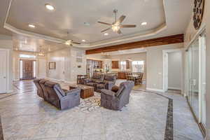 Living room featuring ceiling fan and a raised ceiling