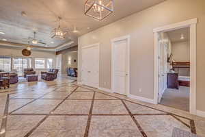 Hallway with a chandelier and a tray ceiling