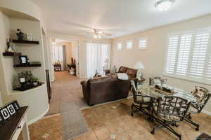 Living room with light tile patterned floors and ceiling fan