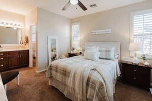 Bedroom with sink, ceiling fan, carpet flooring, and ensuite bath