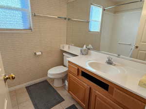 Bathroom featuring toilet, tile patterned flooring, and vanity