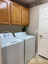 Washroom featuring cabinets and separate washer and dryer