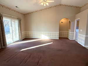 Carpeted spare room with lofted ceiling and ceiling fan