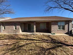 Rear view of property with a patio area and a lawn