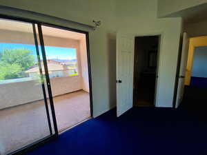 Unfurnished bedroom featuring a closet and dark carpet