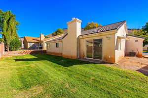 Rear view of house featuring central AC unit and a yard