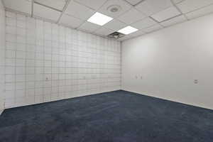 Carpeted empty room with a drop ceiling