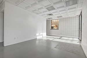 Empty room with concrete floors and coffered ceiling