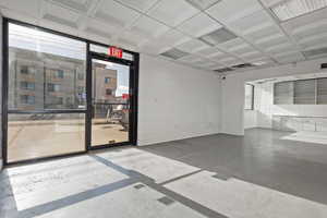 Empty room featuring coffered ceiling and concrete flooring