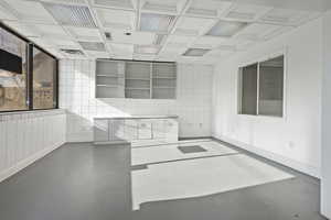 Kitchen featuring coffered ceiling and concrete floors