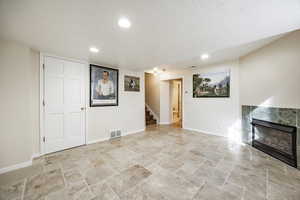 Basement featuring a tile fireplace and a textured ceiling