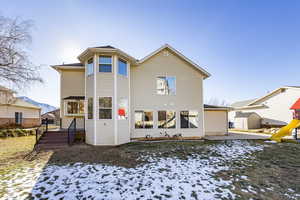 Snow covered property featuring a wooden deck and a playground