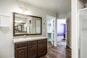 Bathroom featuring vanity, hardwood / wood-style flooring, walk in shower, and a textured ceiling