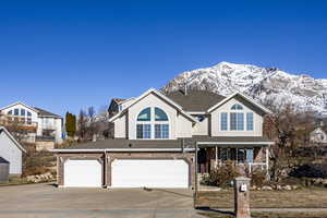 View of front of home with a mountain view, a porch, and a garage