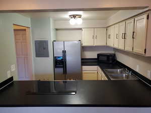 Kitchen featuring sink, black appliances, and electric panel