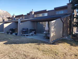 Rear view of house featuring a lawn, central AC unit, and a patio