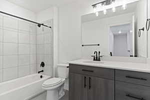 Full bathroom with vanity, toilet, and tiled shower / bath combo