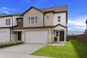 View of front facade with a mountain view, a front yard, and a garage