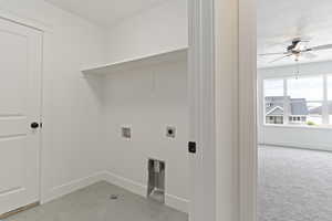 Clothes washing area with light carpet, electric dryer hookup, ceiling fan, hookup for a washing machine, and a textured ceiling