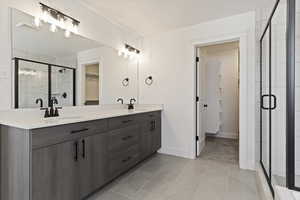 Bathroom featuring an enclosed shower, tile patterned floors, and vanity