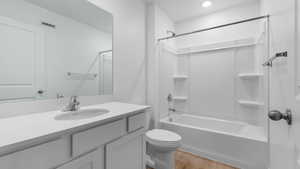 Full bathroom with wood-type flooring, shower / bathing tub combination, vanity, and toilet