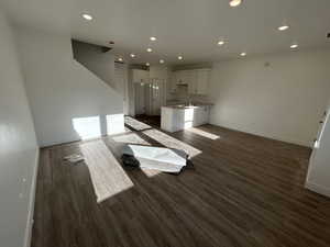 Unfurnished living room with sink and dark hardwood / wood-style floors