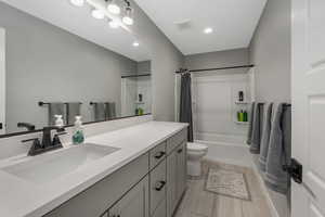 Full bathroom featuring vanity, toilet, and shower / bathtub combination with curtain